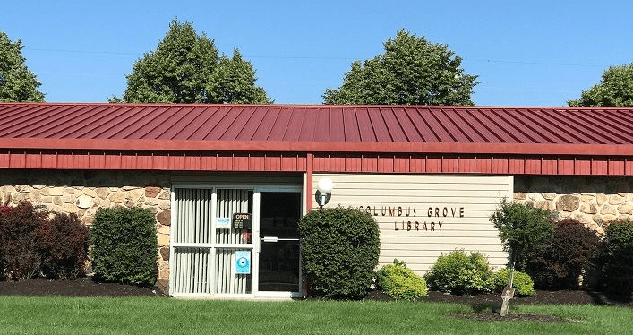 brown stone and tan siding building with rust roof