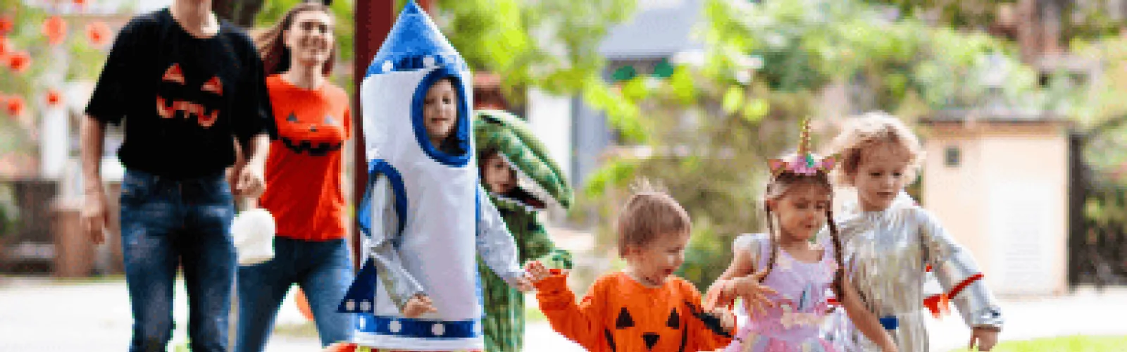 children dressed as a rocket alligator pumpkin unicorn astronaut walking with parents