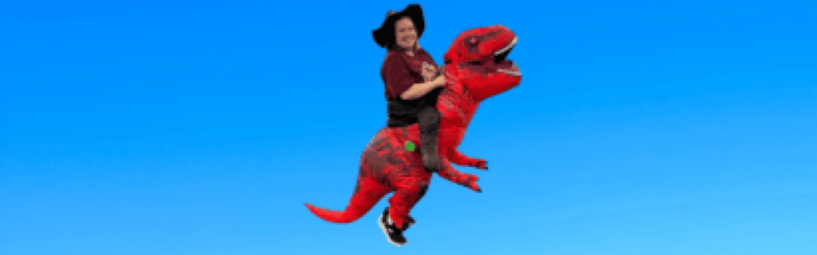 woman with camo safari hat riding a red dinosaur
