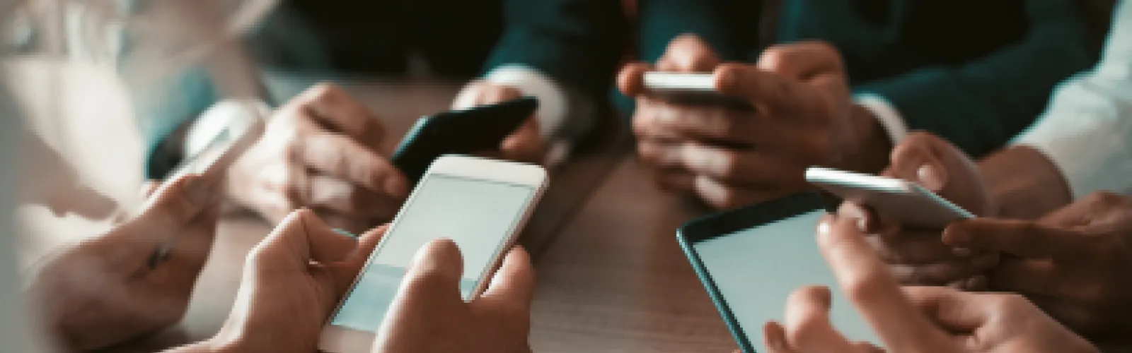 6 people in a circle holding smart phones