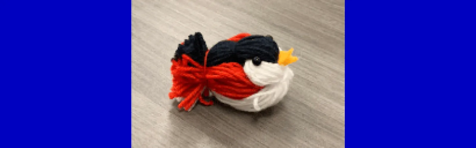 red black white bird made of yarn
